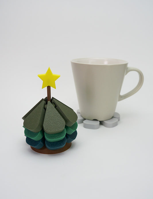 Green 3D printed Christmas tree coaster used with a coffee cup
