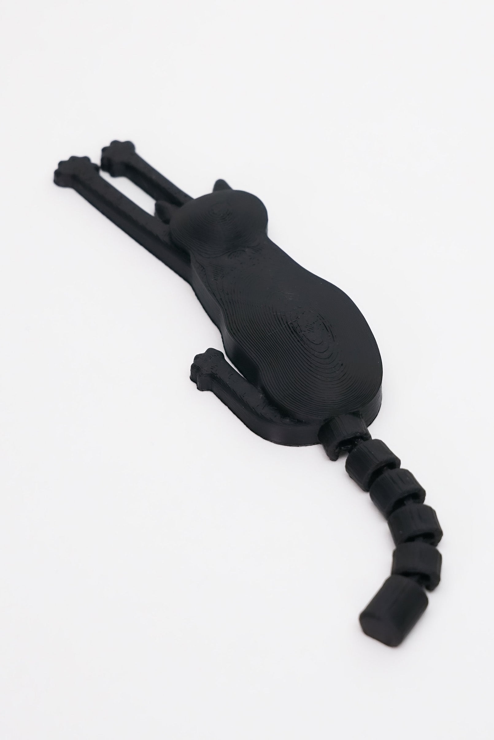3D printed μαύρης γάτας μαγνητάκι με flexy ουρά σε λευκό φόντο