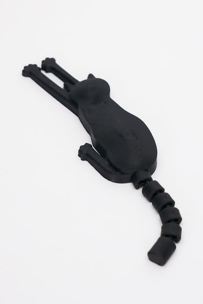 3D printed μαύρης γάτας μαγνητάκι με flexy ουρά σε λευκό φόντο