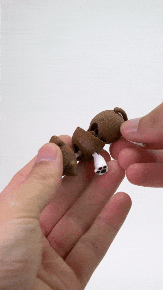 GIF που δείχνει το 3D printed flexy μπρελόκ σκύλου να κινείται στο χέρι