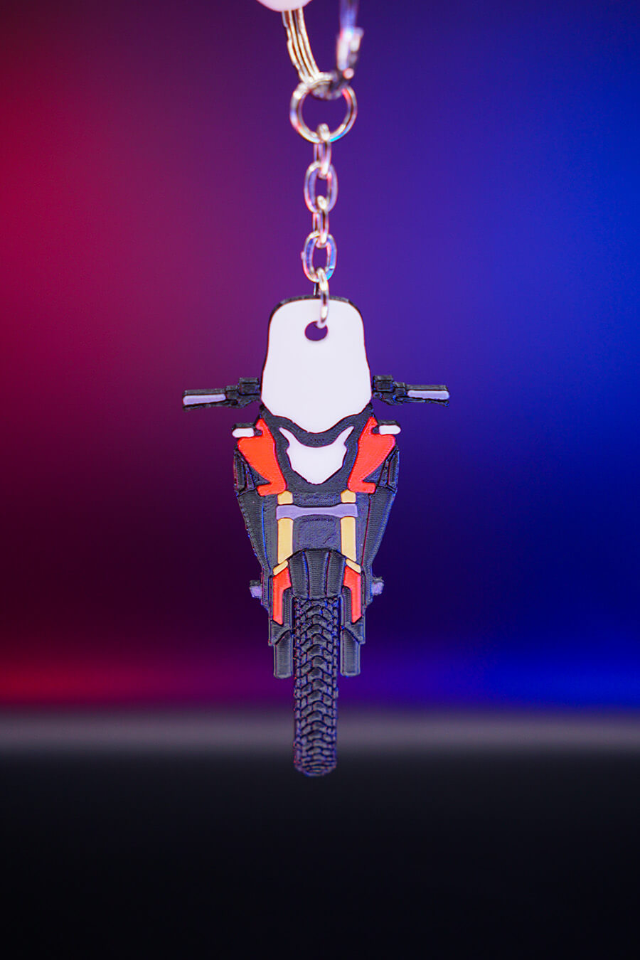 3D printed μπρελόκ Honda CB500X σε κόκκινη έκδοση, κάθετη hero λήψη με φωτισμό φόντου σε μπλε και μοβ αποχρώσεις, προβολή από μπροστά