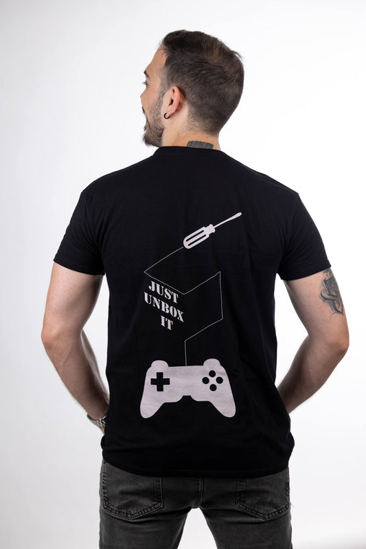 Μαύρη μπλούζα Just Unbox It T-Shirt φορεμένη από μοντέλο, πλάτη με το σχέδιο game controller και logo “Just Unbox It”