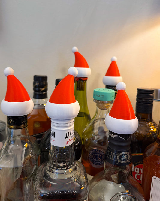 Santa hat bottle toppers on wine bottles used as Christmas party table decoration