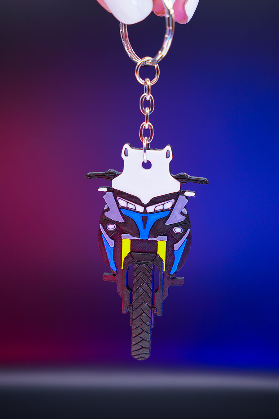 3D printed μπρελόκ Voge DS 525X σε κάθετη hero λήψη με φωτισμό φόντου σε μωβ και μπλε αποχρώσεις, προβολή από μπροστά